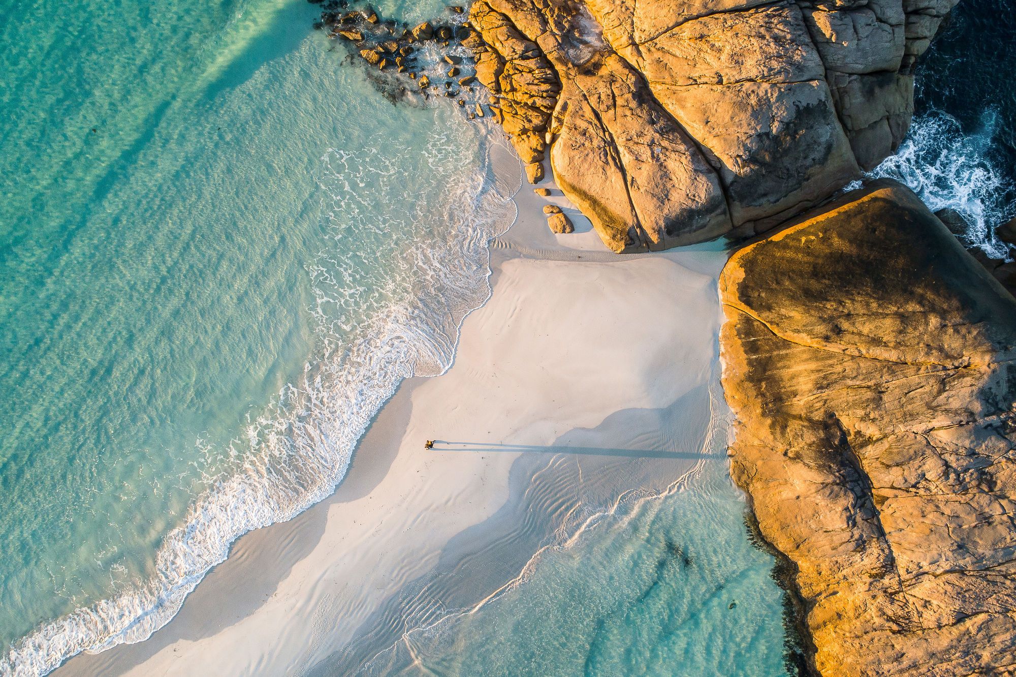 Man walking along sandbar beach, Australia